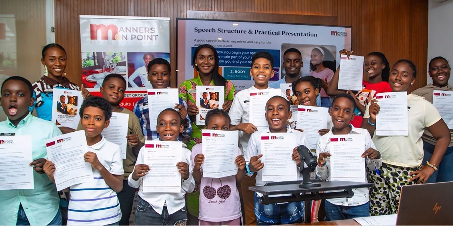 Participants holding up their work during the public speaking and presentation session.