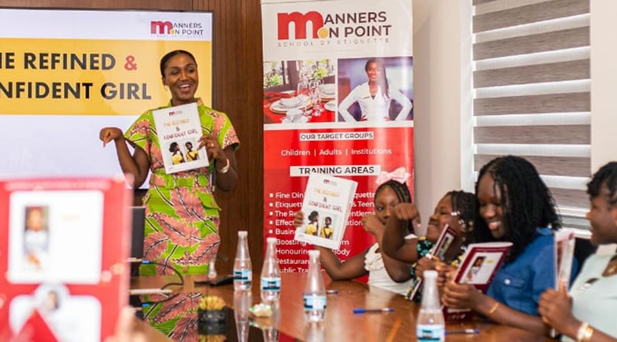 The trainer presenting beside Manners on Point banners during a session.